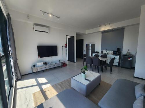 a living room with a couch and a dining room at Urban Suites - Penang in Jelutong