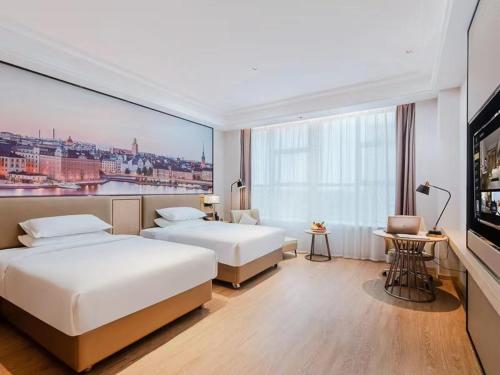 um quarto de hotel com duas camas e uma grande janela em Vienna International Hotel Shenzhen Baolong subway Station branch em Longgang