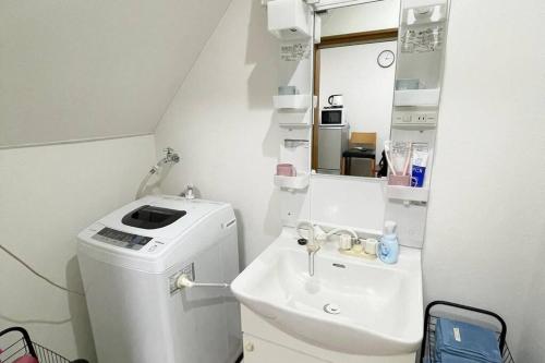 a small bathroom with a sink and a toilet at Rainbow House in Osaka