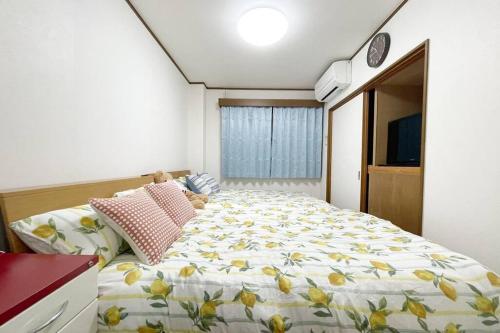 una camera da letto con un grande letto con fiori gialli di Rainbow House ad Osaka