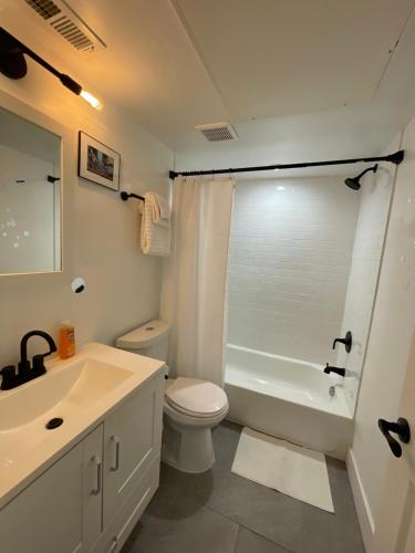 a bathroom with a white toilet and a sink at Mary's Stay Petworth in Washington, D.C.