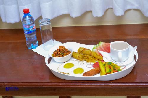 a plate of food with eggs and vegetables on a table at Hotel Cavallino in Kakamega