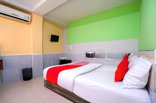 Schlafzimmer mit einem Bett mit roten und grünen Wänden in der Unterkunft Hotel Lendosis Mayor Ruslan in Palembang