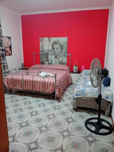 1 dormitorio con cama y pared roja en Beach house en Mondello