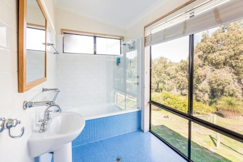 a bathroom with a tub and a sink and a window at Main Break in Dunsborough