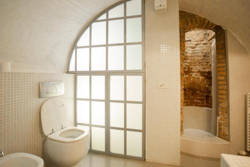 a bathroom with a toilet and a shower and a window at Casa del Sarto in Mantova