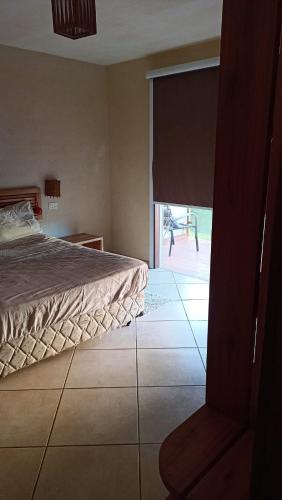 um quarto com uma cama e uma porta de vidro deslizante em Apartamento condomínio Vila la Torre em Porto Seguro