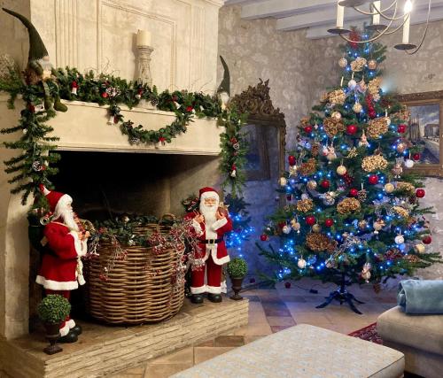 a living room with a christmas tree and santa clauses at Le Murmure des Fées in Issigeac