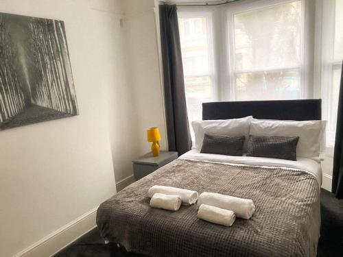 um quarto com uma cama com duas toalhas em Gravesend 2 Bedroom Spacious Stylish Apartment - Sleeps upto 6 - 2 Min Walk to Station em Kent