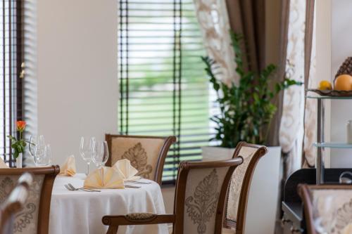 a dining room with a table and chairs with glasses and napkins at Mantar Spa Hotel in Marikostinovo
