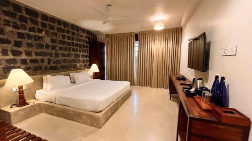 a bedroom with a bed and a brick wall at Mango Hill Yercaud in Yercaud