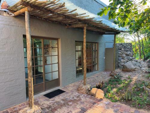 a house with a pergola on a patio at Eloff Guest House and Gallery in White River