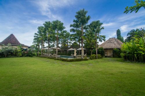 um grande quintal com casas e palmeiras em Aswanaya Villas Ubud em Ubud