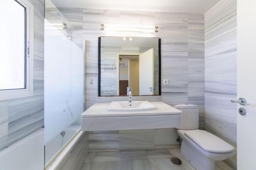 uma casa de banho com um lavatório, um WC e um espelho. em Agua Serena em Roquetas de Mar