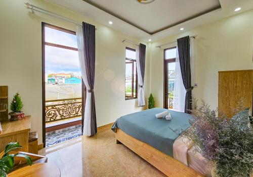 um quarto com uma cama e uma grande janela em Mai DiaMond Hotel em Da Lat