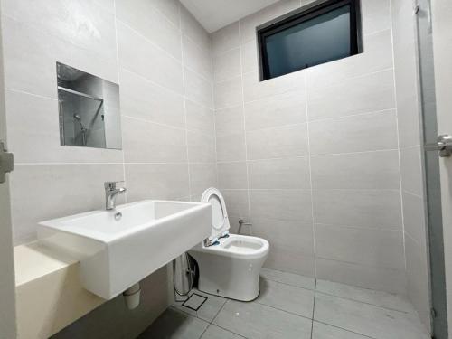 een witte badkamer met een wastafel en een toilet bij 3 Room Cozy Comfy 1-11 pax Old Klang Road 7 min to Midvalley in Kuala Lumpur