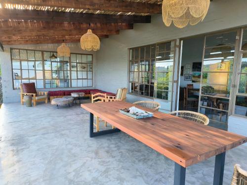 a wooden table on a patio with chairs and tables at Eloff Guest House and Gallery in White River