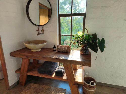 a bathroom with a sink and a mirror on a table at Eloff Guest House and Gallery in White River