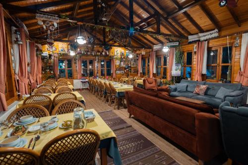 Abant Doğa Köşkü في بولو: غرفة طعام مزودة بالأرائك والطاولات والكراسي