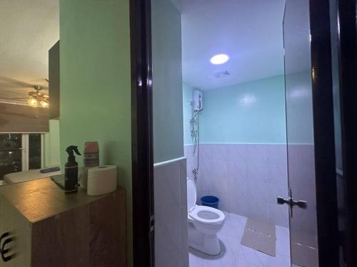 a bathroom with a toilet and a blue light at Fully Furnished Condo with Balcony Fiber Wi-Fi in Lo-oc
