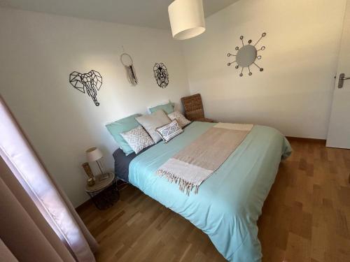 a bedroom with a bed with a sun on the wall at Charmant T3 proche plaine de l’Ain in Saint-Jean-de Niost