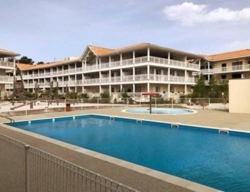 een groot appartementencomplex met een groot zwembad bij La Cigale du Pyla, au cœur de l'écoquartier avec piscine commune in La Teste-de-Buch
