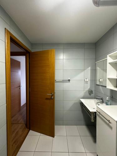 a bathroom with a wooden door and a sink at Gondola Mako Exclusive in Zlatibor