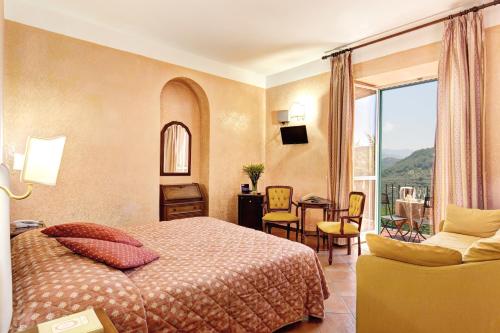 a hotel room with a bed and a balcony at Villa Romita in SantʼAgata sui Due Golfi