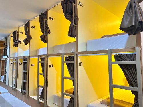 a locker room with yellow walls and mirrors at LONGDOO Hostel in Phi Phi Don