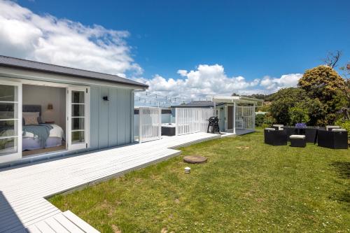 a house with a large backyard with a bedroom at Coco Grove Oneroa - Luxe Escape with Spa Pool in Blackpool