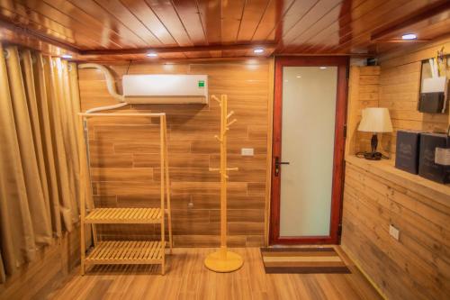 ハノイにあるĐồi Gió Retreatの木製の壁の客室で、暖房、ベンチが備わります。