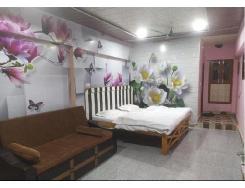 um quarto com uma cama, um sofá e flores em Hotel Dabral, Pipalkoti em Pīpalkoti