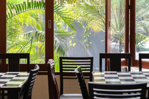 a restaurant with tables and chairs and a palm tree at Tycoon place garden in Pattaya South