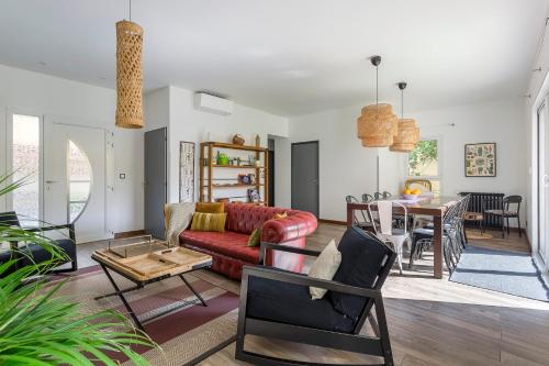 un salon avec un canapé rouge et une table dans l'établissement MAISON EOLE, à Villeurbanne