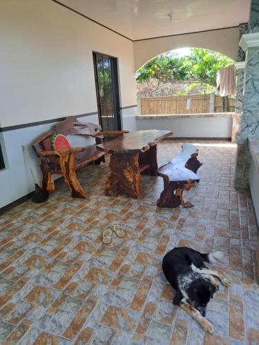 a dog laying on the floor in a room with a table at House of the rising sun in Ibajay