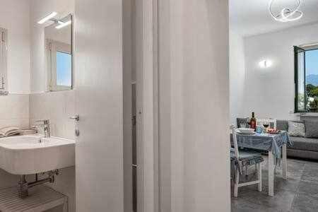 Baño blanco con lavabo y mesa en Sorrento Capo Apartments by Gocce en Sorrento