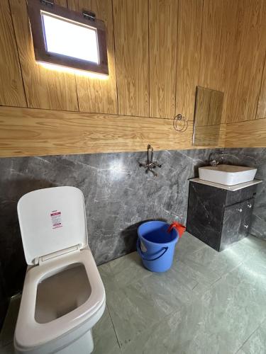 a bathroom with a toilet and a sink at Pangong Pearl in Man