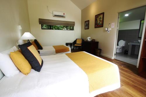 a hotel room with two beds and a bathroom at Mulu National Park in Mulu