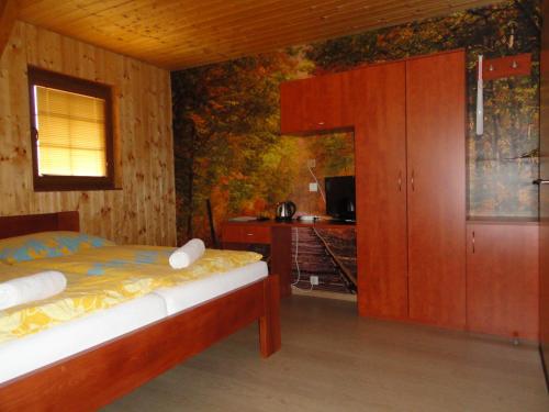 a bedroom with a bed and a cabinet and a television at Penzion Žumberk in Nové Hrady