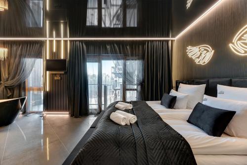 Hollywood Jacuzzi Suite by Downtown Apartments في غدانسك: غرفة نوم بسريرين مع وسائد سوداء وبيضاء