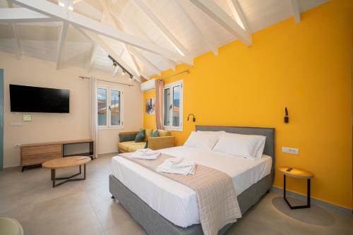 sypialnia z dużym łóżkiem i żółtą ścianą w obiekcie Amazona w mieście Sami