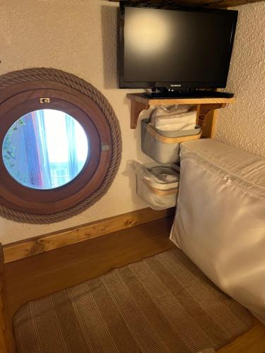 une chambre avec un lit, une télévision et une fenêtre dans l'établissement Appartement proche centre ville 4 personnes proche télécabine wifi couchages 2 mezzanines 1BZ Résidence La Tourette, à Cauterets