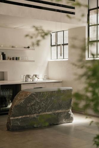a kitchen with a sink and a stone bench at kodō hotel - Heart of LA Arts District in Los Angeles