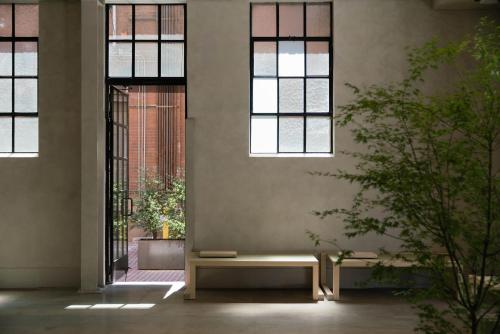 a room with a bench in front of windows at kodō hotel in Los Angeles