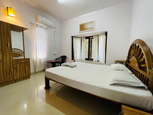 a bedroom with a large bed and a window at RiTAS in Varkala