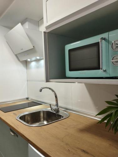 a kitchen with a sink and a microwave at Ciudad Rodrigo Centro VuT in Ciudad-Rodrigo