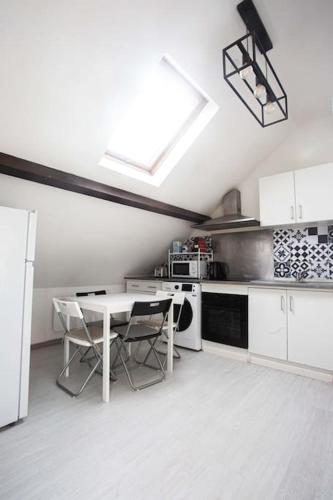 - une cuisine blanche avec une table et une cuisinière dans l'établissement Love House 5, à Aulnay-sous-Bois