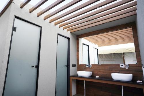 a bathroom with two sinks and a mirror at Teela- The Glamping Resort in Udāsar