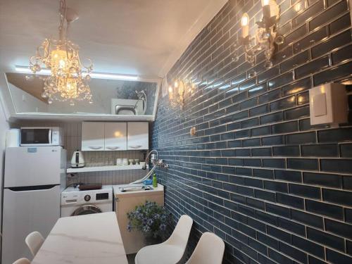 a kitchen with a brick wall and a chandelier at Seochon Orak Stay in Seoul