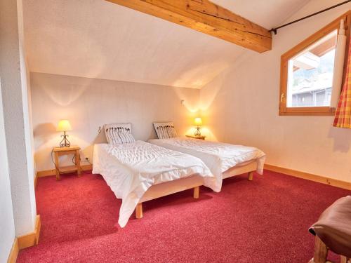 two beds in a room with red carpet at Duplex 4 chambres avec piscine et parking au centre du village - 10 pers - FR-1-505-122 in Notre-Dame-de-Bellecombe